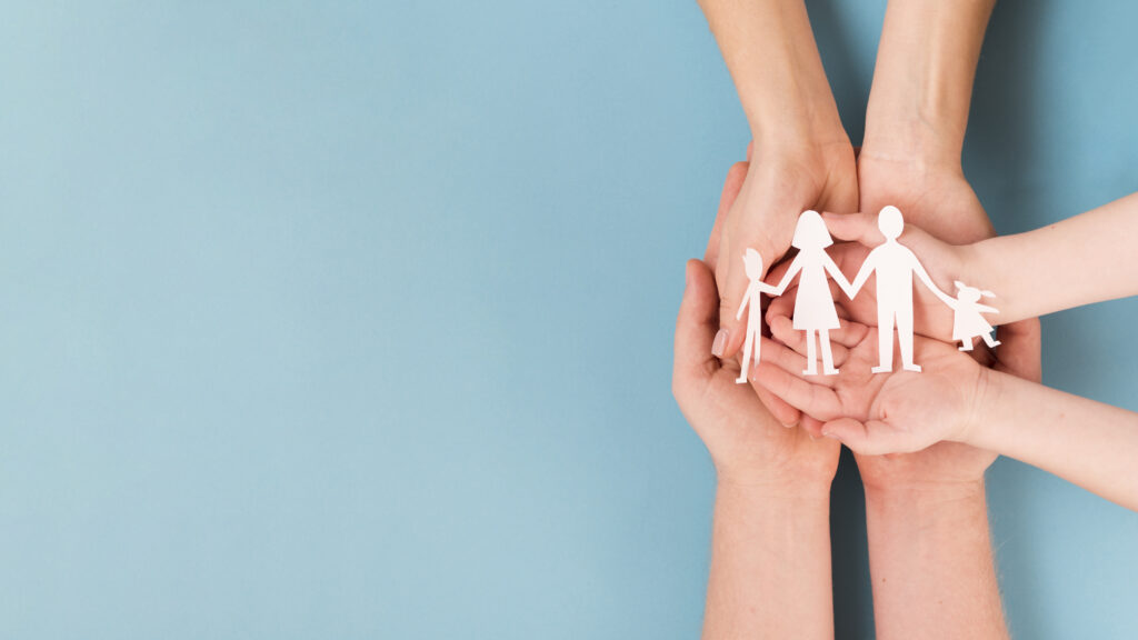 tres pares de mãos segurando uma família em recorte de pepal